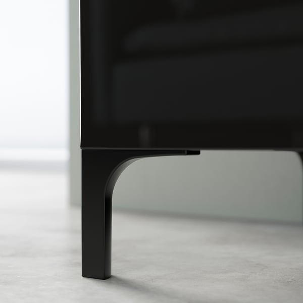 Des pieds en métal noir surélèvent un meuble TV. Design minimaliste, support solide et nettoyage facile.