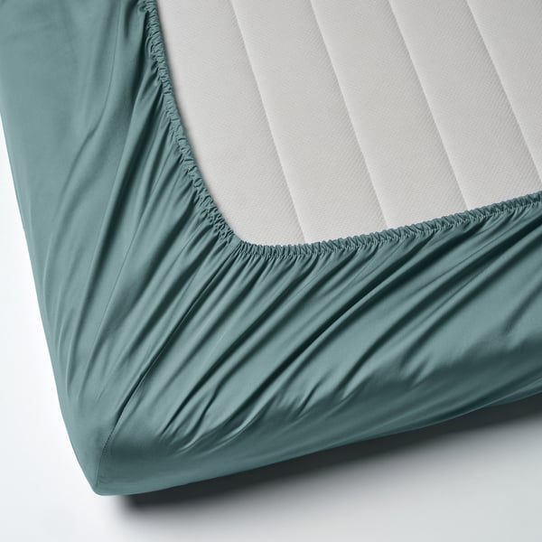 Drap-housse avec bordure élastique, couleur bleu-vert, tissage satin lisse.