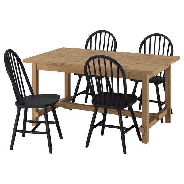 L’ensemble de salle à manger NORDVIKEN. Il comprend une table extensible marron clair entourée de quatre chaises noires avec des dossiers et des sièges en fuseau.
