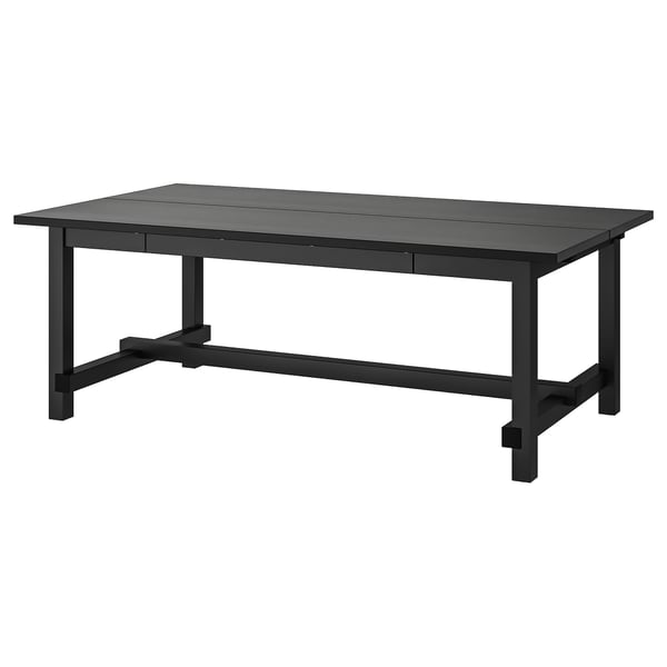 Table de salle à manger extensible NORDVIKEN noire avec bois, pieds robustes et rallonges intégrées pour les intérieurs modernes.