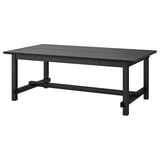 Table de salle à manger extensible NORDVIKEN noire avec bois, pieds robustes et rallonges intégrées pour les intérieurs modernes.