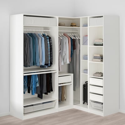 Une armoire d’angle blanche présentant un rangement organisé des vêtements avec des tringles de suspension, des étagères et un tiroir pour une utilisation efficace de l’espace.