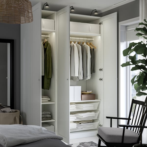 Placard moderne avec des vêtements organisés, des étagères, des paniers et des lumières.