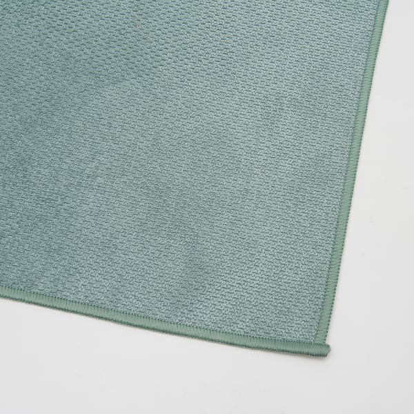 Chiffon en microfibre verte, propre et soigneusement plié, mettant en valeur une texture de qualité.