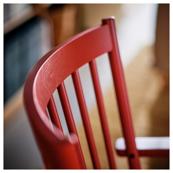 Dossier de chaise rouge, design élégant ; La finition en bois lisse suggère un savoir-faire de haute qualité.