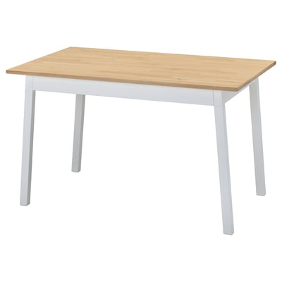 Table à manger en bois nommée PINNTORP, peut accueillir quatre personnes, pieds blancs, plateau en bois naturel. Style scandinave.