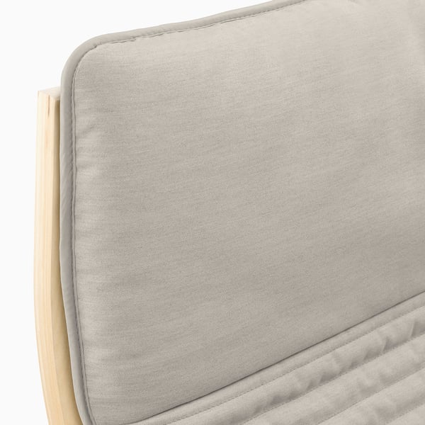 Gros plan sur un coussin poang doux et beige avec un tissu lisse et des coutures détaillées.