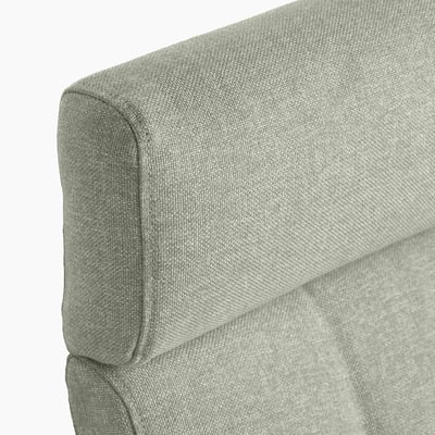 Gros plan d’un coin de fauteuil en tissu gris, mettant en valeur sa texture et son design rembourrés de haute qualité.