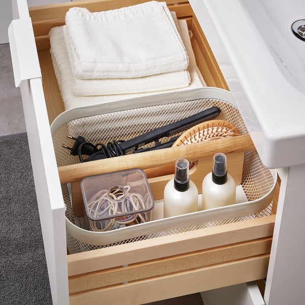 Tiroir de salle de bain organisé avec séparateur RISATORP : serviettes, brosses à cheveux, bouteilles et accessoires soigneusement rangés.