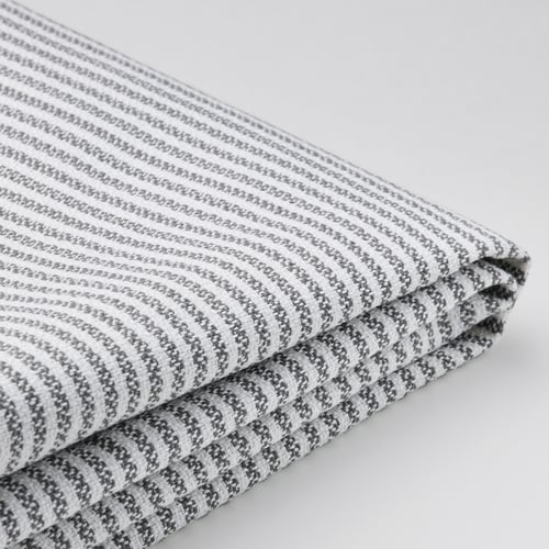 Tissu plié à rayures grises et blanches sur surface blanche.