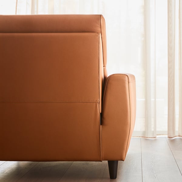 Gros plan d’un fauteuil inclinable en cuir beige moderne, mettant en valeur son design élégant et sa sellerie de haute qualité.