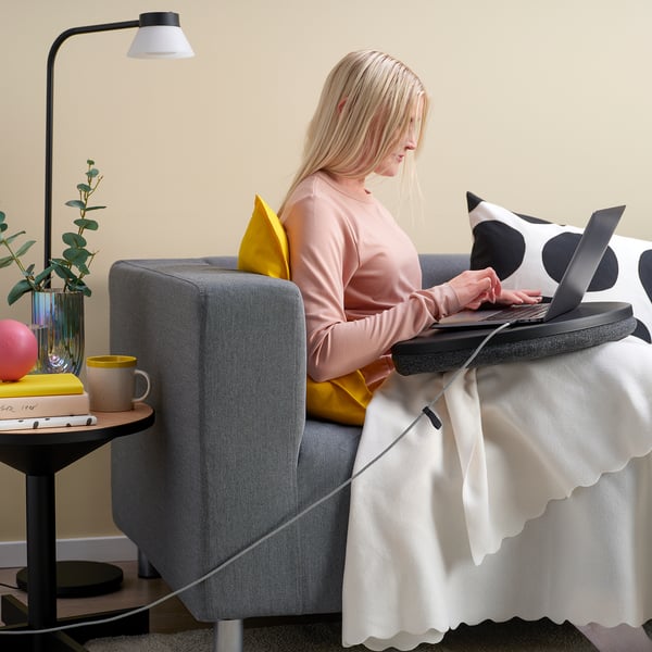 Femme travaillant sur ordinateur portable dans un fauteuil, câble usb-c éclairé