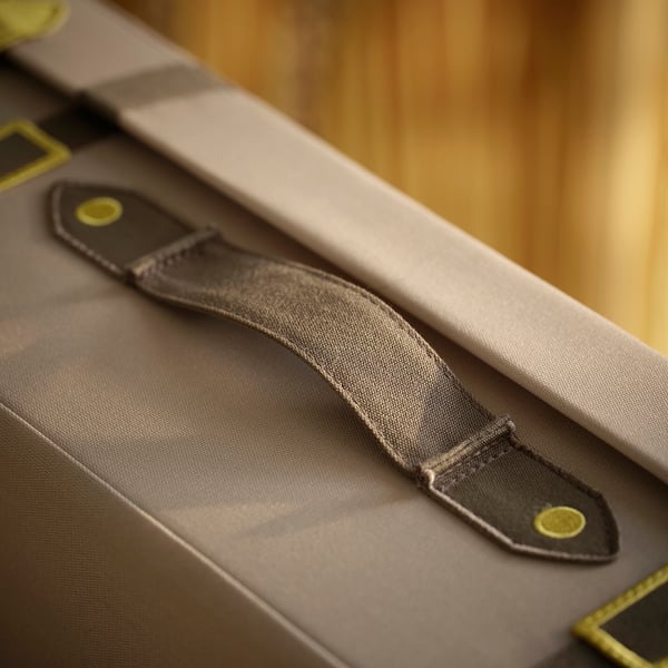 Gros plan de la sangle de sac en polyester recyclé durable avec boucle jaune sécurisée.