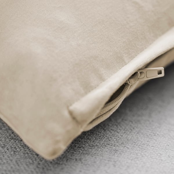 Gros plan d’une housse de coussin en velours de coton doux avec une fermeture éclair soignée, mettant en valeur sa texture et son savoir-faire de haute qualité.