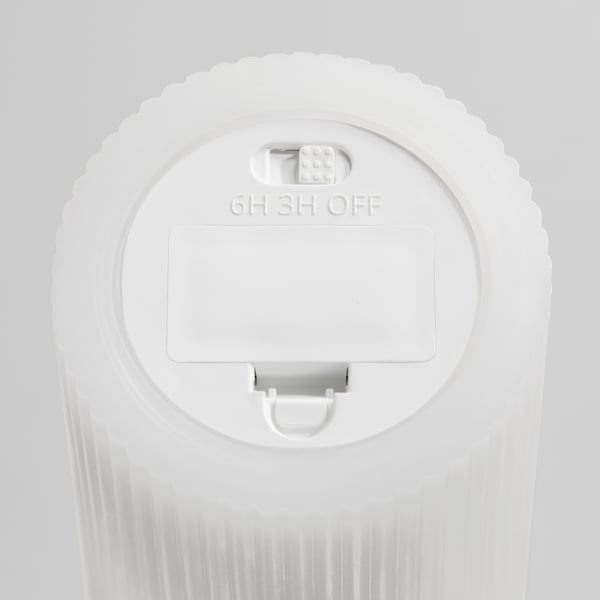 Bougie LED blanche avec minuterie : 6h allumée, 3h éteinte. Surface texturée, contrôle bouton, poignée de transport.