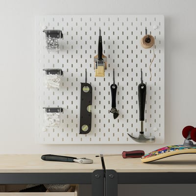Panneau perforé SKÅDIS blanc avec des outils et des conteneurs au mur.