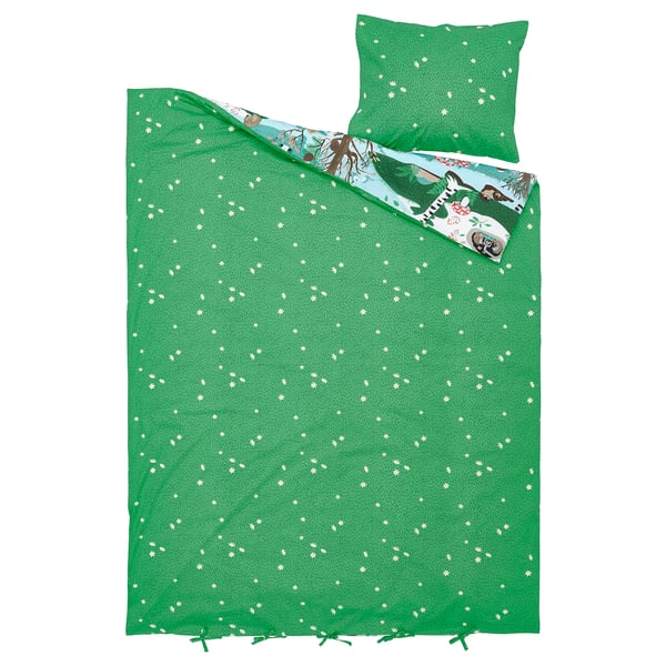 Parure de lit verte avec imprimés de fleurs blanches, avec oreiller assorti et design sur le thème de la forêt.