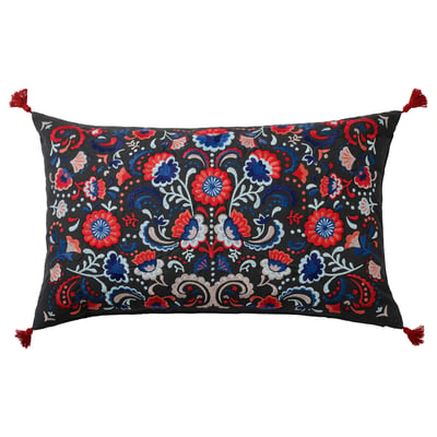 Coussin rectangle brodé floral vibrant dans une base sombre, rouge, bleu, avec pompons et garnissage en plumes de canard.
