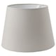 Un abat-jour SKOTTORP gris, de forme cylindrique, fabriqué en tissu écologique et cadre en plastique.