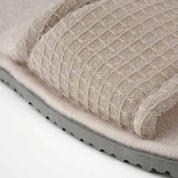 Gros plan sur des pantoufles souples en matériau recyclé avec semelle rembourrée.
