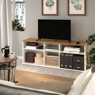 Banc TV SKRUVBY en chêne avec télévision, livres et rangement.