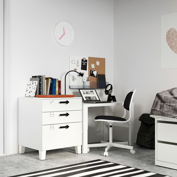 Petit bureau blanc dans la chambre avec chaise noire, livres et horloge. Design moderne et minimaliste.