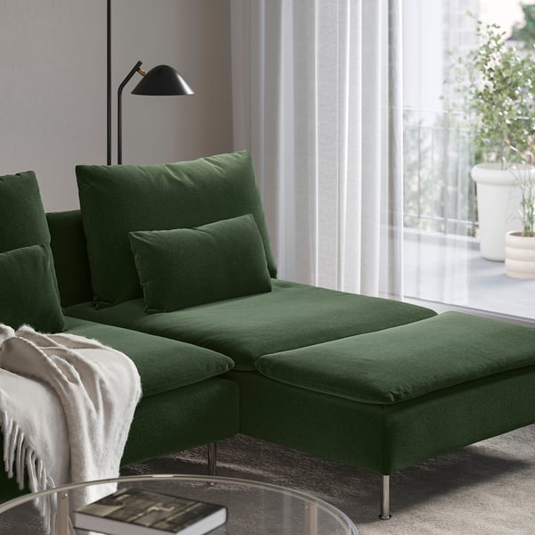 Chaise longue SÖDERHAMN vert foncé près d’une fenêtre avec rideaux, avec deux coussins et une position réglable pour la détente.
