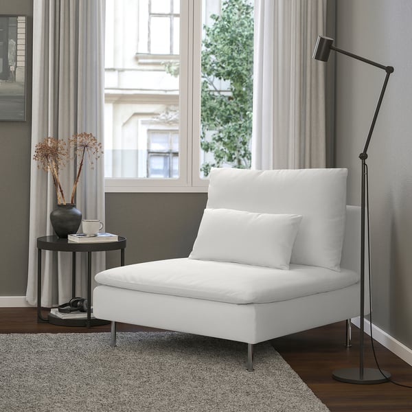 Salon minimaliste moderne avec chaise SÖDERHAMN blanche, table d’appoint noire, lampadaire et vue sur la fenêtre.