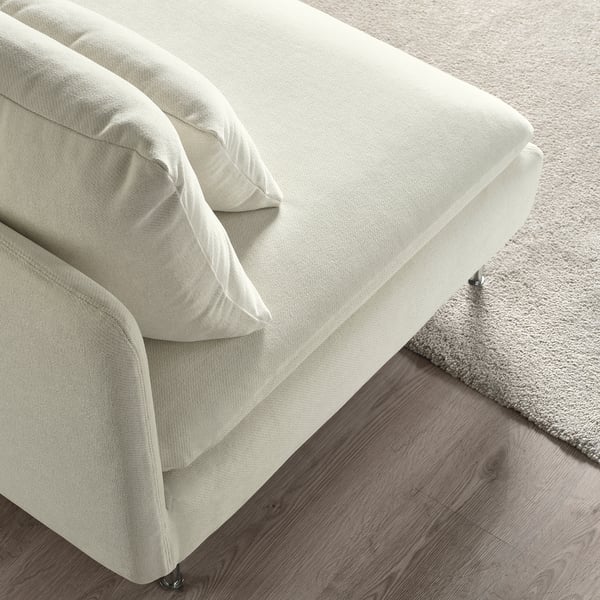 Canapé beige moderne, à profil bas, aux lignes élégantes et aux coussins moelleux sur un sol en bois.