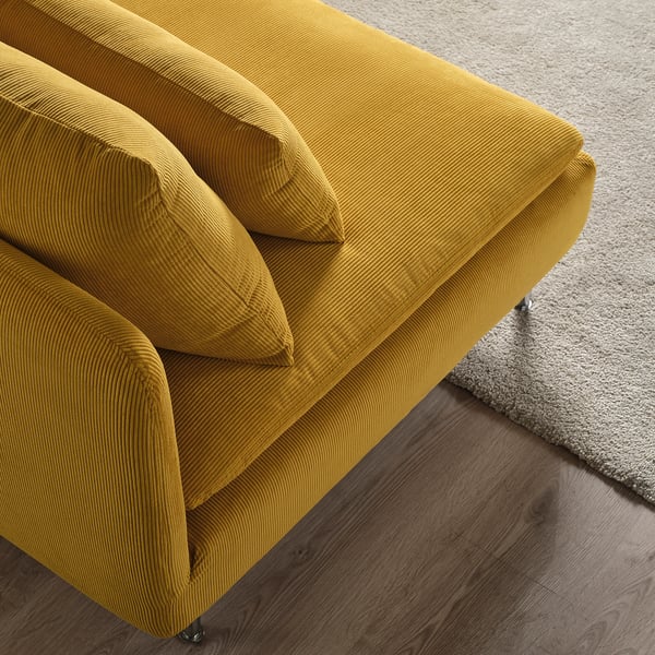 Canapé jaune vif, coussins moelleux, plancher en bois.