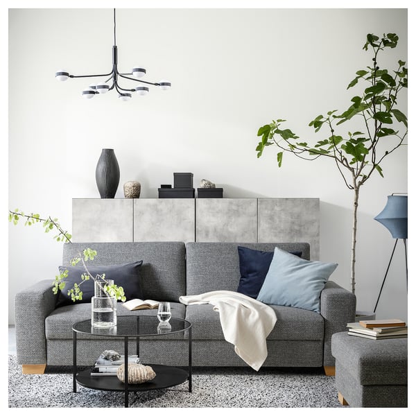 Salon moderne avec canapé SÖRVALLEN gris, table basse en verre, plantes et suspensions.
