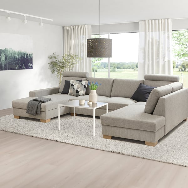 Canapé sectionnel SÖRVALLEN gris moderne dans une chambre minimaliste avec chaise, table basse, tapis et lampes.