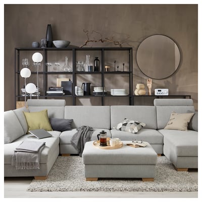 Salon moderne avec canapé sectionnel SÖRVALLEN gris clair, table basse en bois, étagères décoratives et miroir rond.