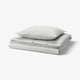 Un ensemble de couette SOLFIBBLA avec des rayures grises et blanches. Fait de coton doux et écologique, c’est un design rayé classique.