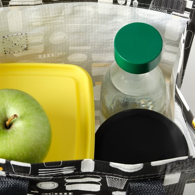 Porte-bouteille isotherme noir avec récipient jaune et pomme verte, illustré avec la bouteille SPARTANSK.