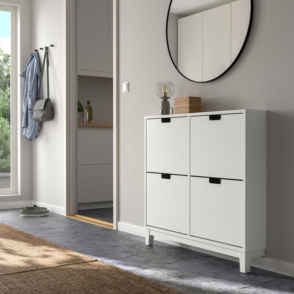 Armoire à chaussures STÄLL blanche dans l’entrée avec 4 compartiments, miroir et crochets pour ranger les manteaux.