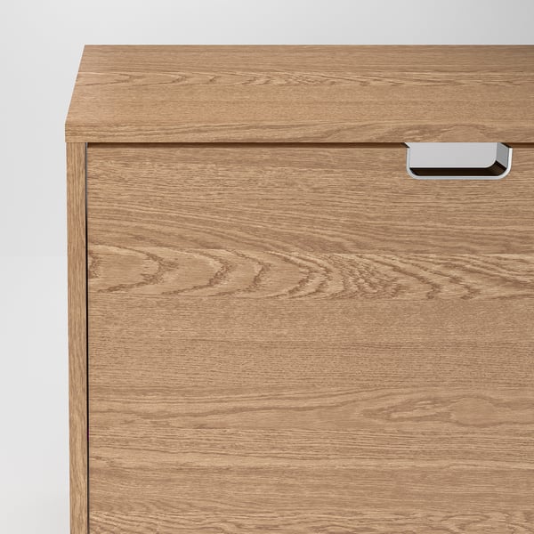 Un gros plan d’une armoire à chaussures en bois, mettant en valeur sa finition lisse et sa poignée robuste. Un savoir-faire de qualité avec des motifs de grain clairs et naturels.