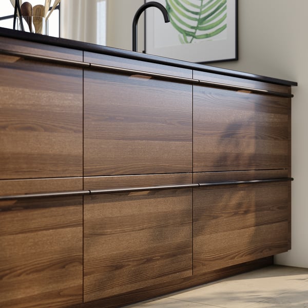 Cuisine moderne avec des armoires en bois brun foncé, avec des poignées élégantes, contre un mur clair.
