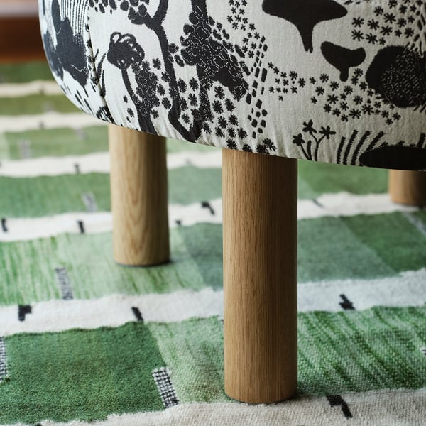 Des pieds arrondis en bois soutiennent une assise rembourrée, qui fait partie de l’ensemble de pouf STOCKHOLM 2025.