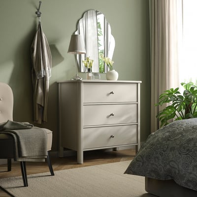 Commode STOREMOLLA blanche avec miroir, lampe et tiroirs dans la chambre à coucher.