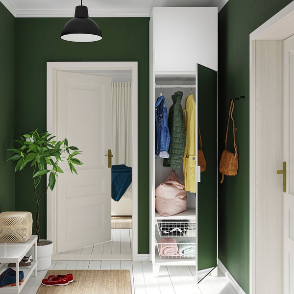 Entrée contemporaine : murs végétaux, sol blanc, placard ouvert, porte miroir, plante, banc, lumière.