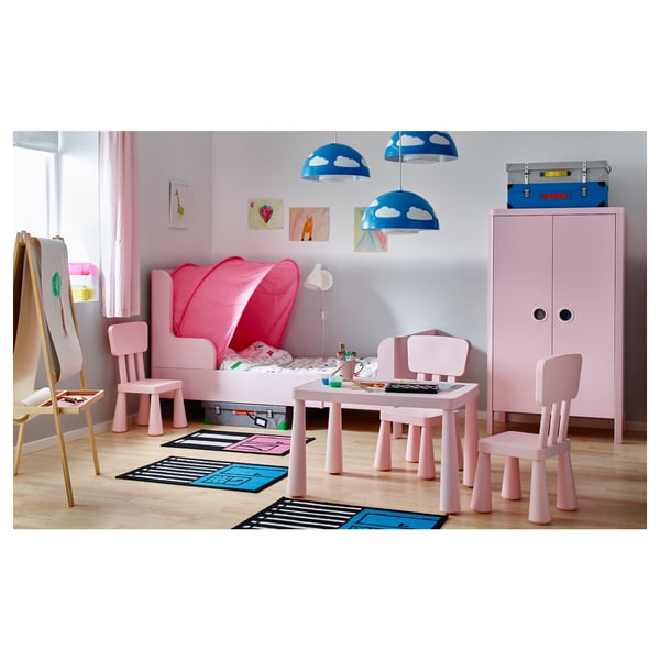 Chambre d’enfant rose ludique avec une tente de lit confortable, une petite table et des chaises, éclairées par des lampes nuages bleues.