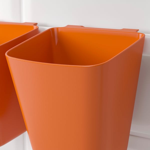 Bacs de rangement en plastique orange vif, propres et robustes, montés sur un mur blanc, idéaux pour organiser les articles.