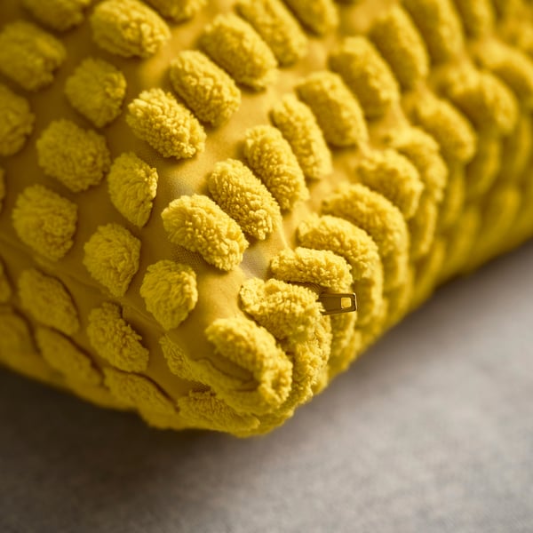 Gros plan de la housse de coussin jaune douce avec un détail de fermeture éclair visible.