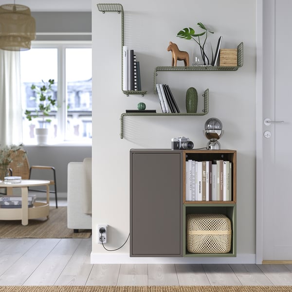 Espace de vie moderne avec étagère murale SVENSHULT. Le design élégant en noir et bois peut contenir des livres, un appareil photo et des objets de décoration, créant ainsi un espace confortable et contemporain.