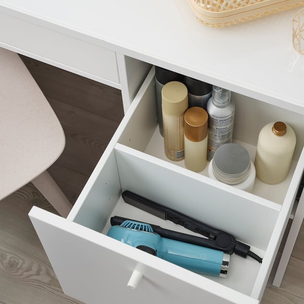 Ouvrez le tiroir blanc avec sèche-cheveux, crèmes et bouteilles. Mécanisme de fermeture en douceur visible.