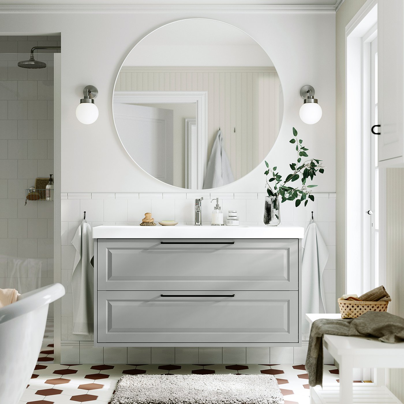 Vanité de salle de bain grise avec miroir, lumières et plantes.