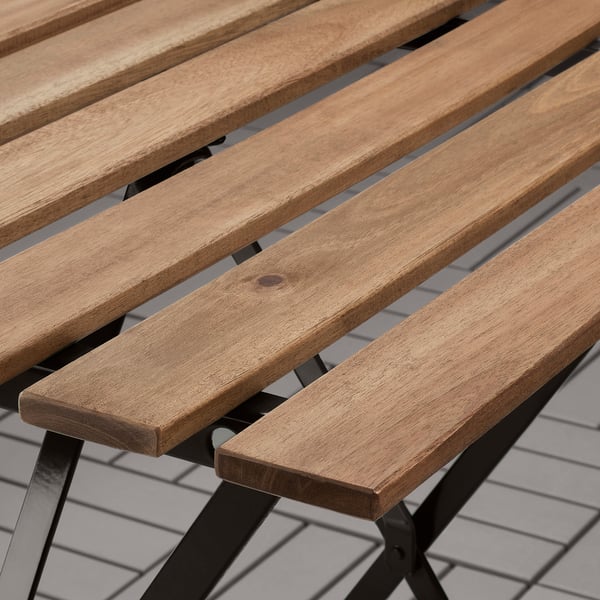 Banquette à lattes en bois avec cadre métallique, témoignant d’un savoir-faire durable.