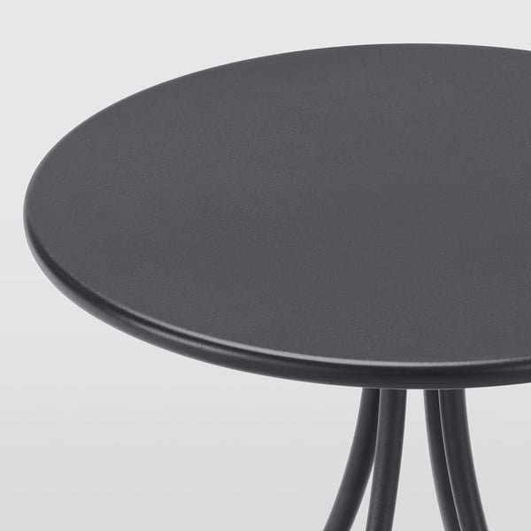 Petite table d’appoint noire élégante avec plateau lisse et pieds robustes.