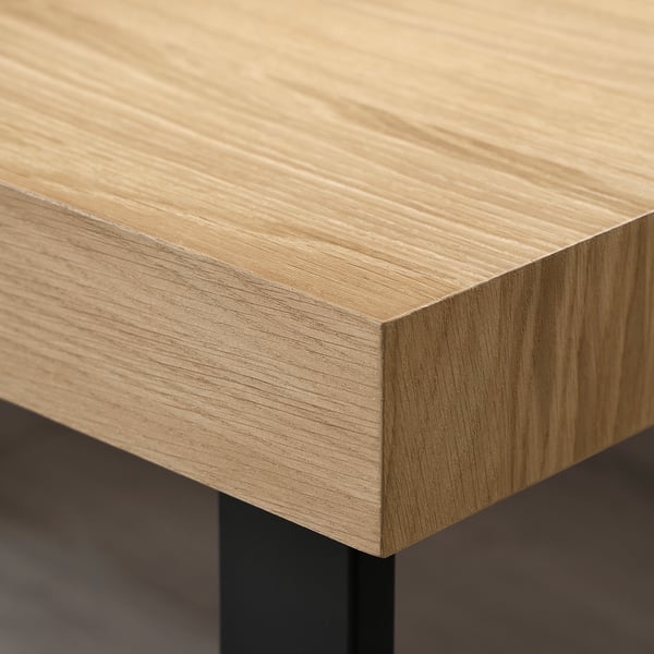 Gros plan du bord d’une table basse en bois avec une finition lisse en placage de chêne clair.